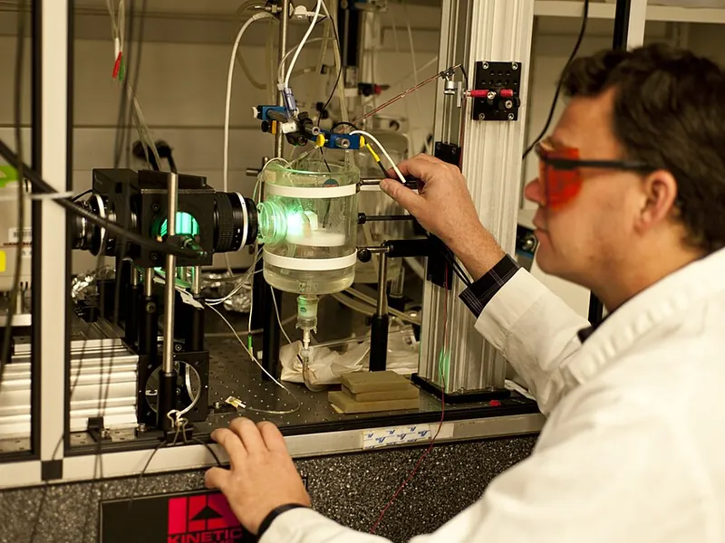 Researcher working with an optical biophysics setup